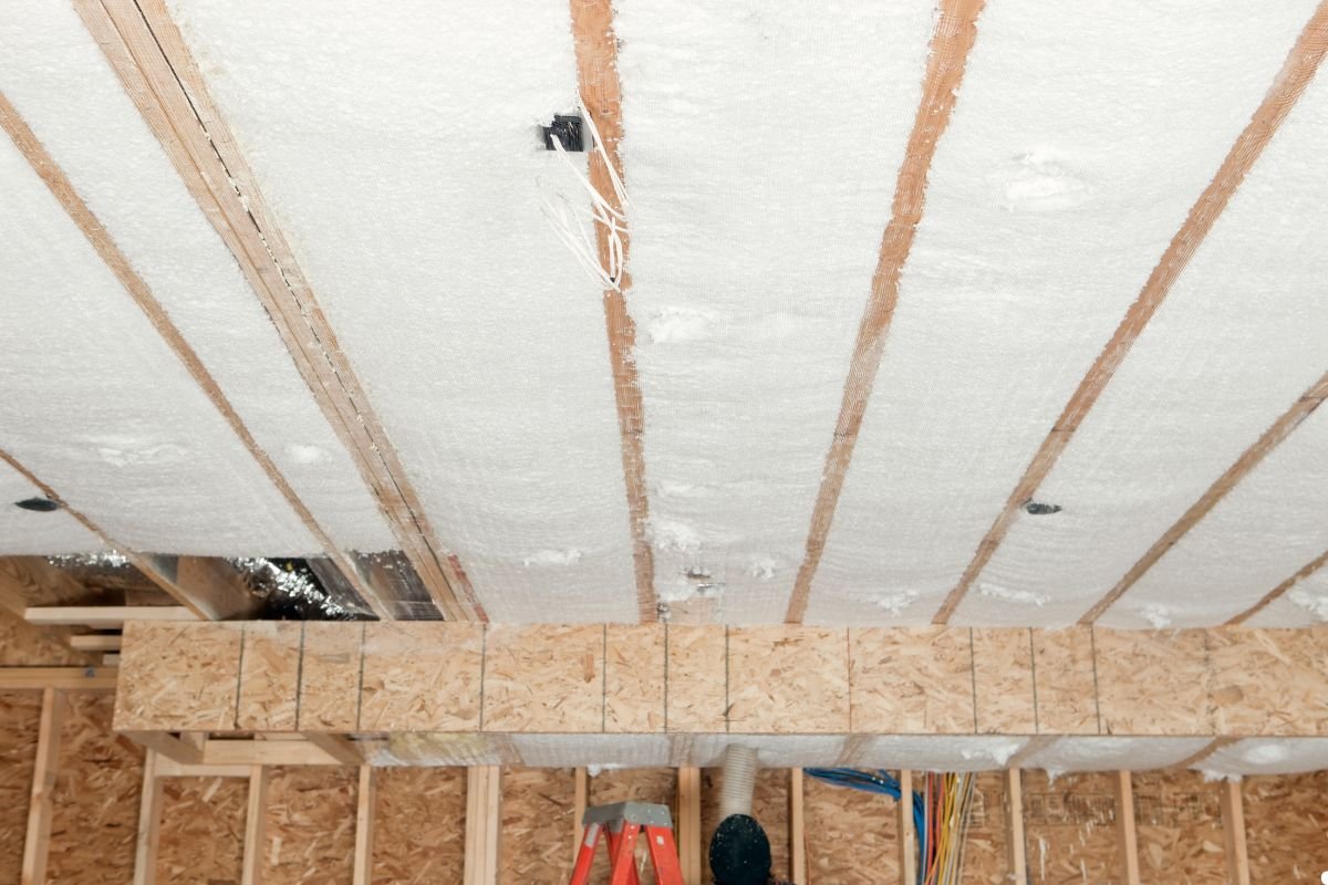 A ceiling featuring insulation material and various tools scattered across it, indicating ongoing maintenance work.