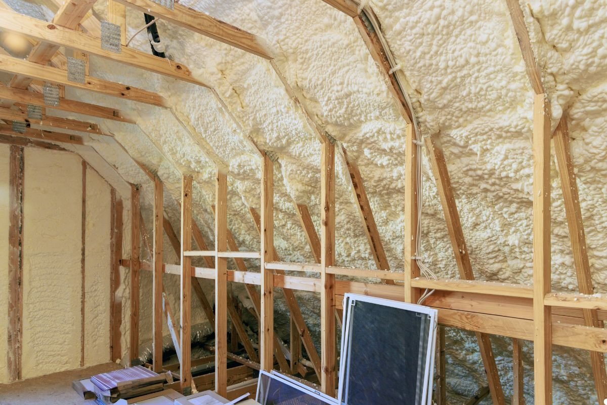 Insulation installed in an attic, featuring wood framing and layers of insulation material for energy efficiency.