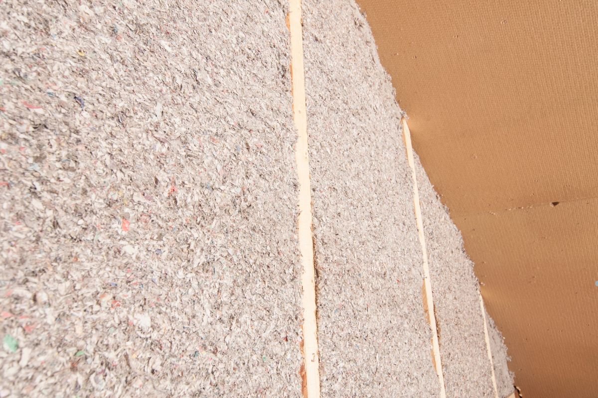  A wall covered in insulation with a piece of wood, illustrating project scope and timing optimization.